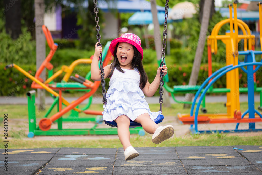 Cute little girl having fun with swing in the park.Children playground. Cute little girl having fun with swing in the park.Children playground.