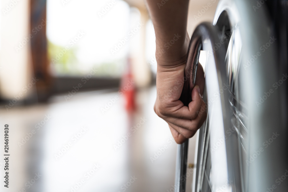 closeup disabled man hand on wheel of wheelchair - obrazy, fototapety, plakaty 