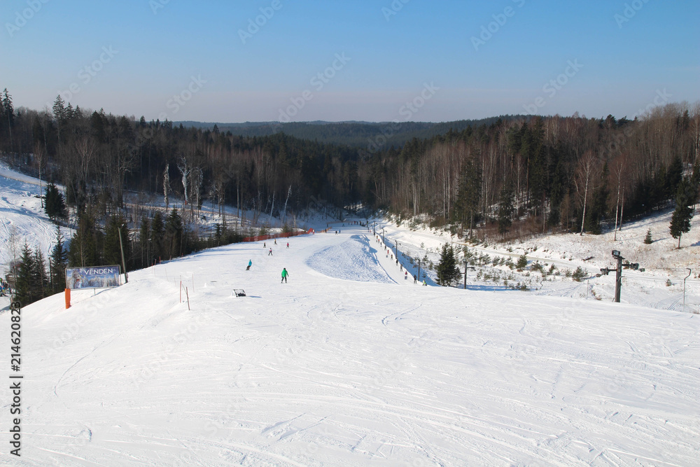 Ski slope, people skiing down the hill, mountains view. Cesis. Latvia