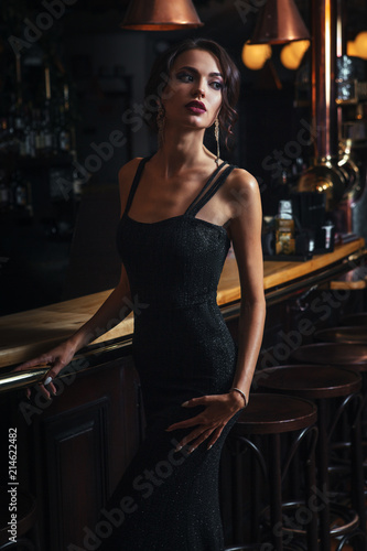 Foto elegant lady in black dress, in restaurant at a bar