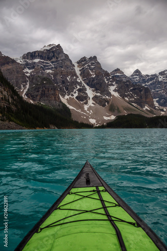 Kayaking in Glacier Water surounded by the beautiful Canadian Rocky Mountains. Taken in Moraine Lake, Banff National Park, Alberta, Canada.