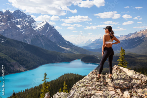 Young girl enjoying the beautiful Canadian Rockies Landscape view during a vibrant sunny summer day. Taken in Peyto Lake, Banff National Park, Alberta, Canada.