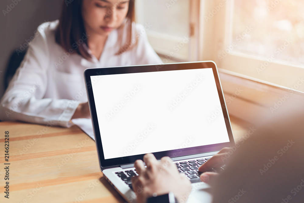 Businessman hand working blank screen laptop on wooden desk in office. Mockup screen for Ads.