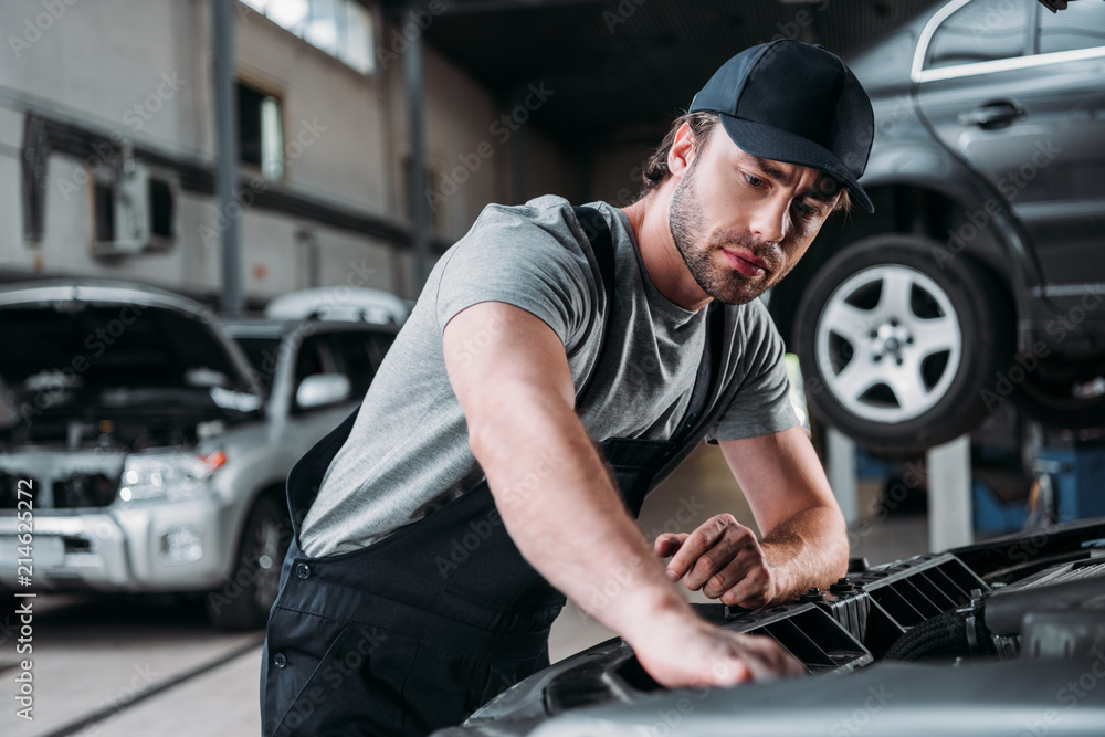 professional auto mechanic working with car in repair shop professional auto mechanic working with car in repair shop