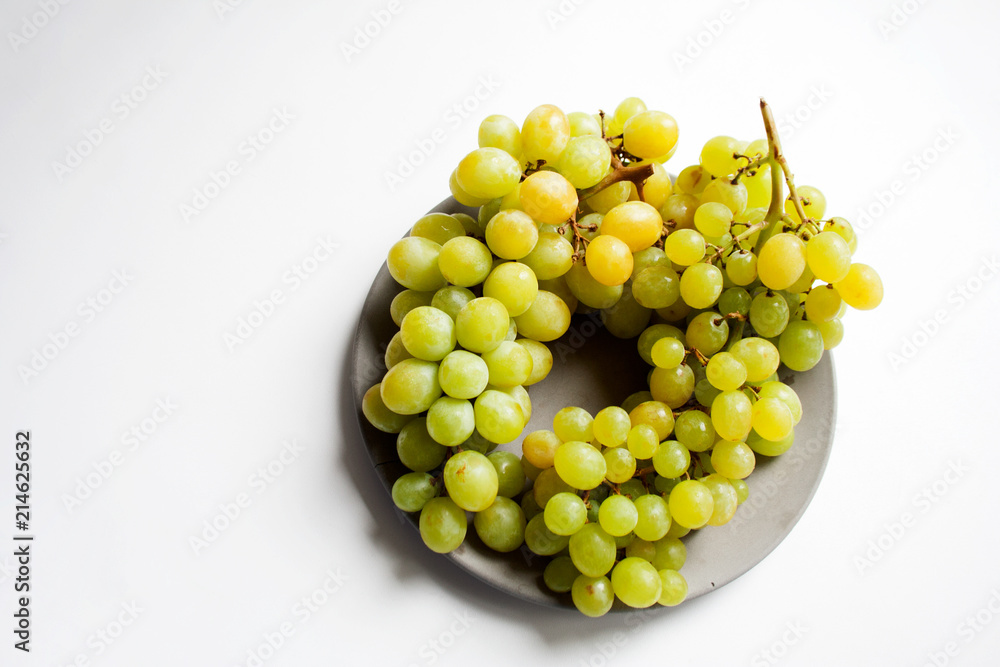 Ripe white seedless grape on grey concrete plate from a high angle view with copy space