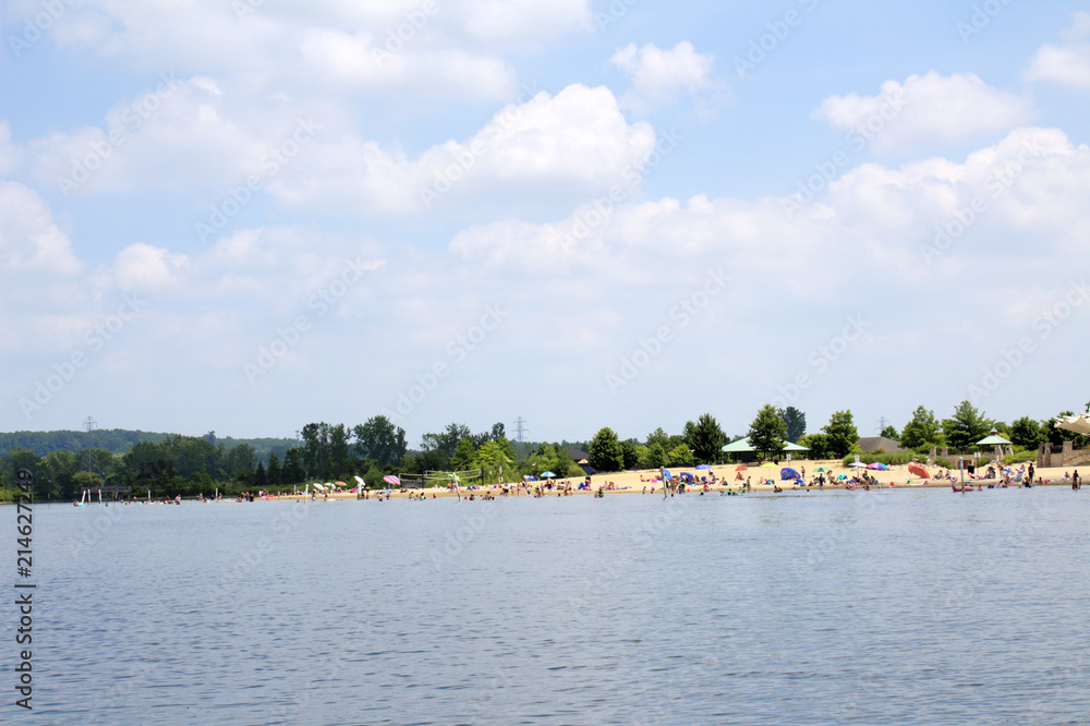 Busy Beach with Swimmers and Sunbathers on Sunny Blue Sky White Cloud Fun Summer Day