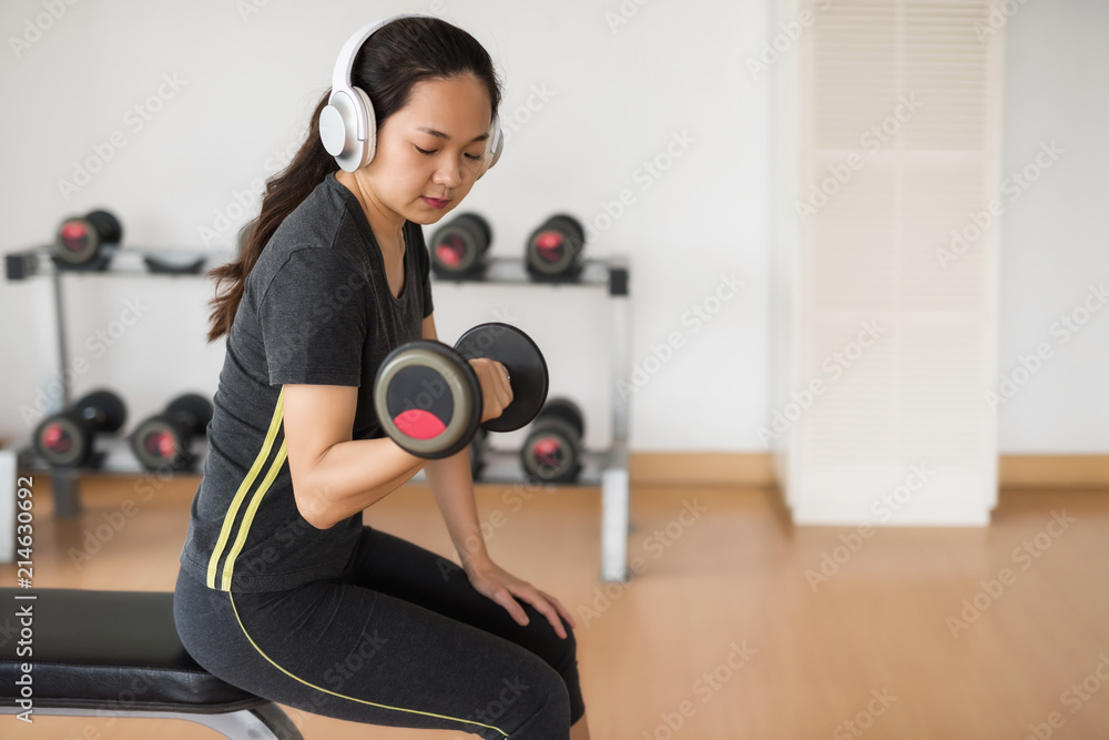 Fototapeta premium Fitness woman with earphone play dumbbell