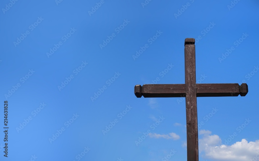 Wooden cross on a background of blue sunny sky