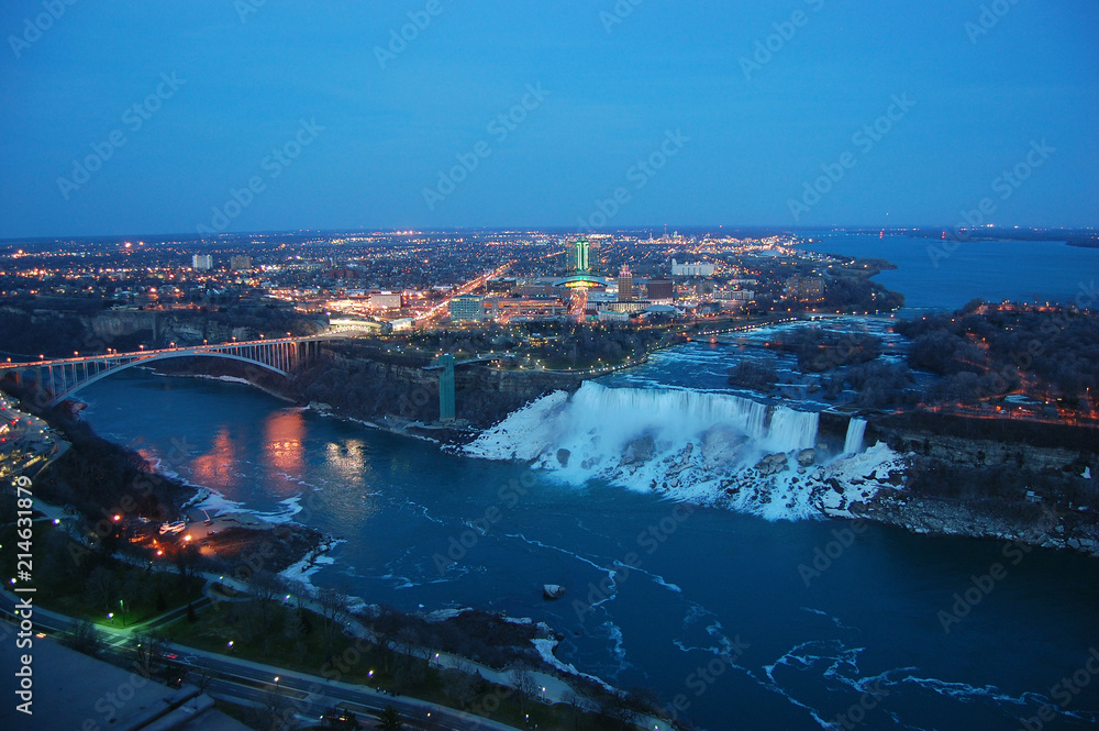 Aerial View of Rainbow Bridge and American Falls of Niagara Falls at night in winter, New York State, USA.