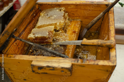 wooden tub box with honey and honey combs with tools for honey © malcev852