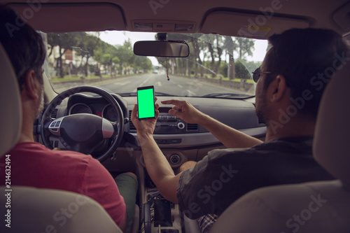 Mockup image of a hand holding and using green mobile phone screen in car
