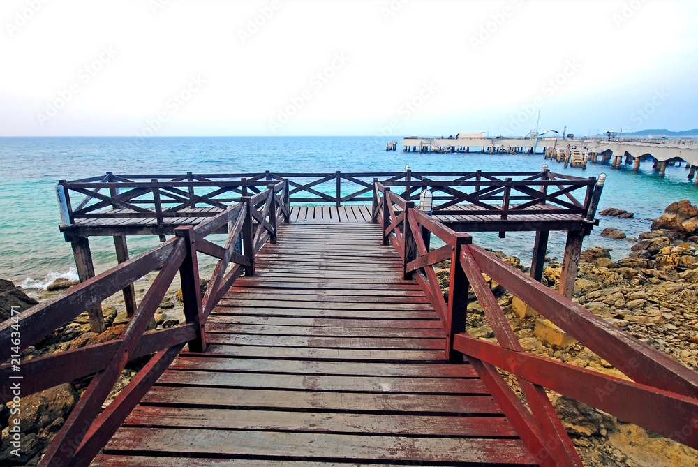 Fototapeta premium The wood bridge beside the sea, the walk way for sight seeing the seascape