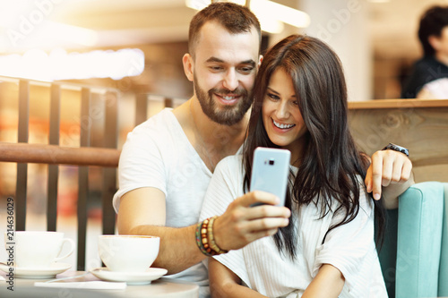 Romantic couple dating in cafe and using smartphone © Kalim