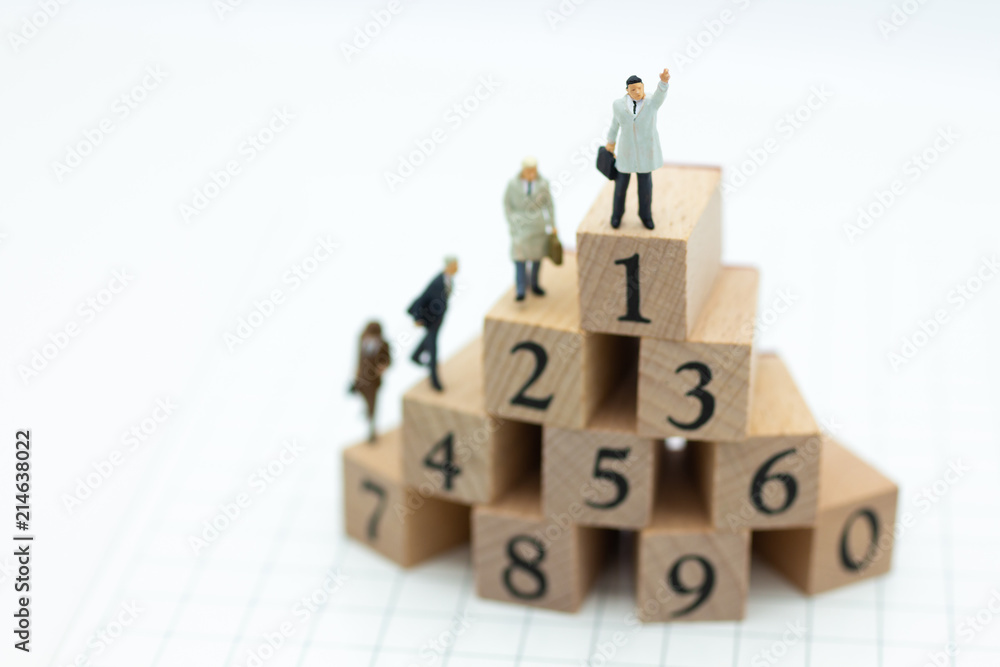 Miniature people : Businessman standing on wooden blocks with sequential numbers , win and loser. Image use for business concept. Miniature people : Businessman standing on wooden blocks with sequential numbers , win and loser. Image use for business concept.