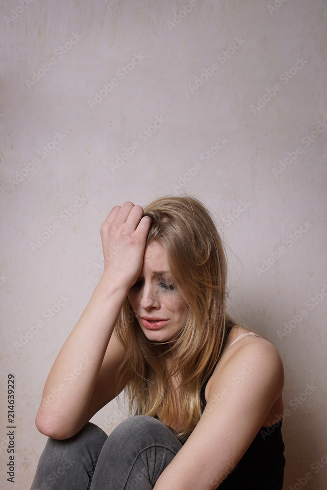 sad young woman with tear-stained face and smudgy makeup from crying sad young woman with tear-stained face and smudgy makeup from crying
