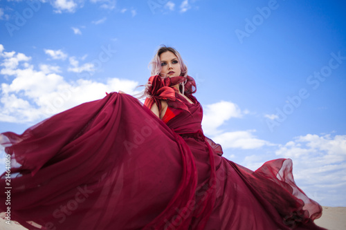 Girl in red. Beautiful young woman in a scarlet dress flying © Ulia Koltyrina