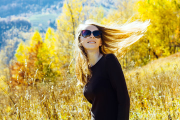 Foto auf Acrylglas Gelb girl colorful autumn forest high mountains carpathians landscape enjoy view perspective sunglasses brown dress sunlight yellow sky blue  © NataliAlba