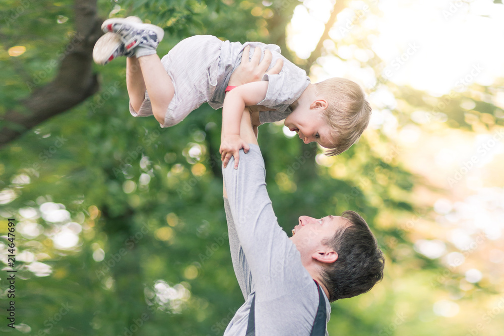 Fototapeta premium Father with kid son in park. Portrait of happy dad with child boy spending time together and playing outdoor.
