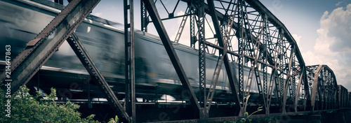 Cuadro en lienzo Old rusty truss bridge with moving freight train over the Red River on the borde