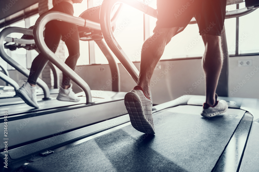 Close up. Man and Young Woman on Treadmills in Gym