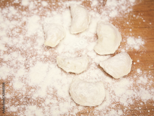 flour and dumplings on wooden board photo