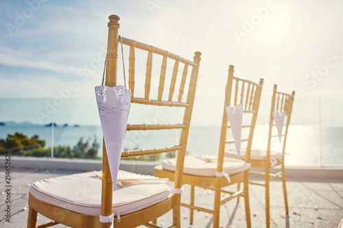 Close-up the gold chiavari chairs for beach wedding venue with cone of rose petal hanging