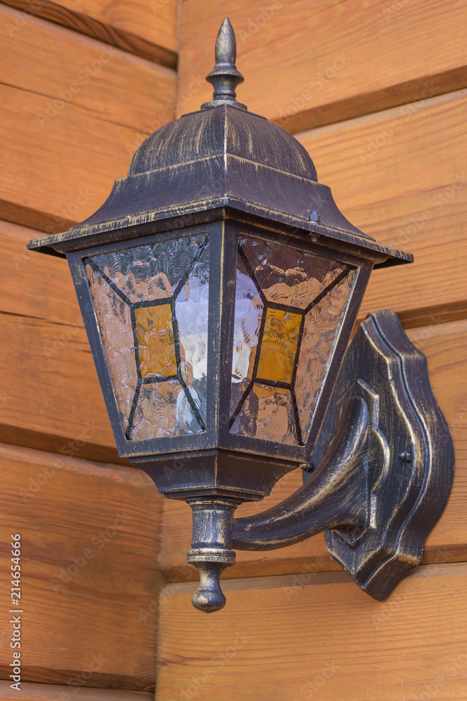 A beautiful street lamp on a wooden house. Lighting and comfort.