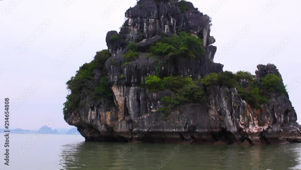 Green mineral water of Ha Long Bay reflect a rock formation protruding out of the water. Green mineral water of Ha Long Bay reflect a rock formation protruding out of the water.