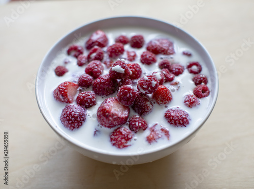 Raspberry with milk in a white bowl