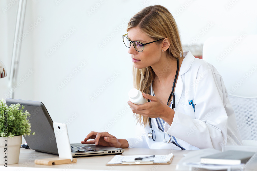 Female doctor working with laptop and researching some medication information in the consultation. Female doctor working with laptop and researching some medication information in the consultation.