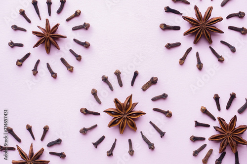 Composition of star anise and cloves on pink background. Abstract flat pattern, top view photo