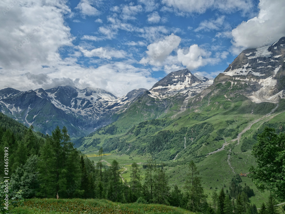 Gebirgslandschaft mit Berg Hohe Dock an der Hochalpenstraße im Natiionalpark Hohe Tauern in Österreich mit Sonne, blauer Himmel, Wolken