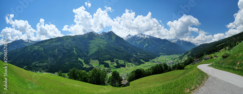 Panoramafoto von Bramberg am Wildkogel, eine Landschaft in den Alpen bei Sonnenschein mit blauem Himmel und Wolken