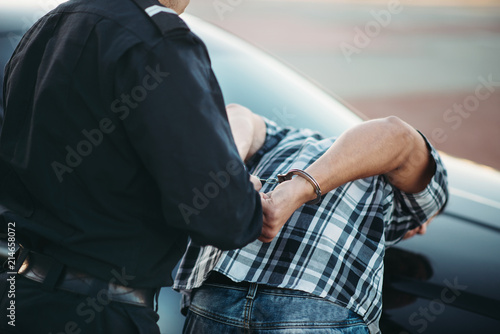 Police officer arrests the driver violator on road photo