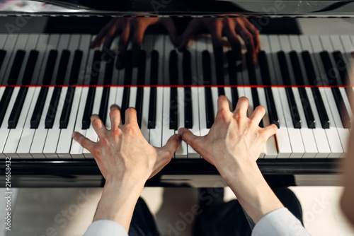 Photography Male pianist hands on grand piano keyboard
