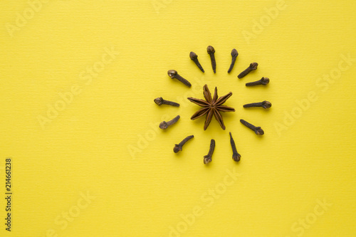 composition of star anise and cloves on a yellow background. Abstract flat pattern, top view photo