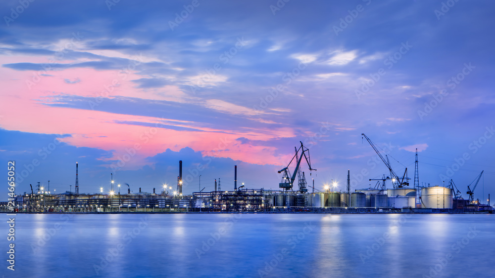 Panorama of a petrochemical production plant against a dramatic colored cloudy sky at twilight, Port of Antwerp, Belgium.