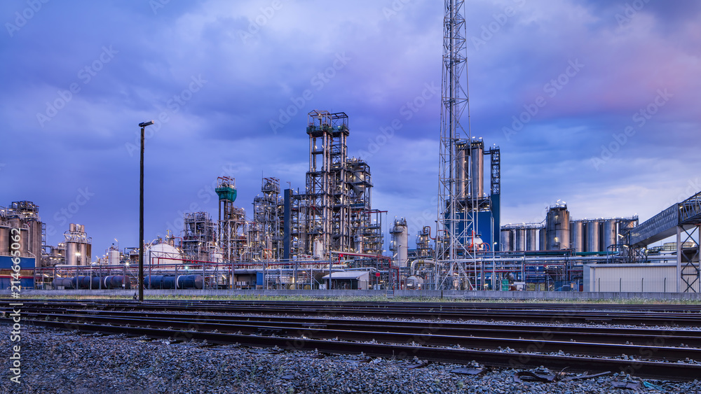 Petrochemical production plant against a cloudy blue sky at twilight, Port of Antwerp, Belgium.