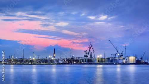 Panorama of a petrochemical production plant against a dramatic colored cloudy sky at twilight, Port of Antwerp, Belgium.