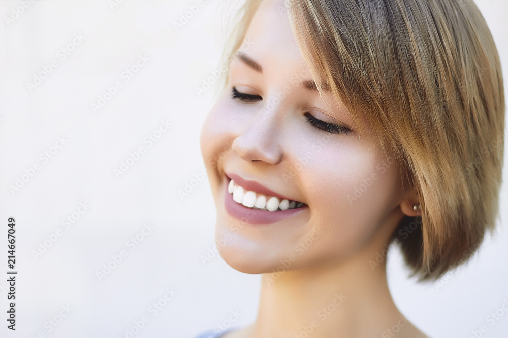 Attractive young blonde woman smiling with closed eyes enjoying her time outdoors. Attractive young blonde woman smiling with closed eyes enjoying her time outdoors.