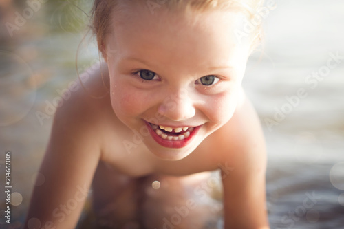 Portrait of beautiful happy smiling little white girl bathing in the sea close up Fototapet