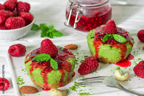 green matcha vegan raw cakes with raspberries  jam mint and nuts. healthy delicious food