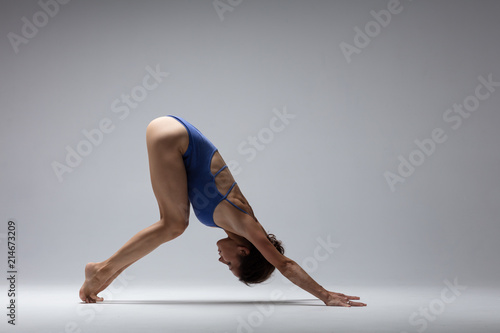Young beautiful yoga woman is posing in studio
