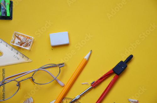 Back to school set in yellow. , notebook, pen, pencils, scissors, markers, chair, clip, glasses, compass, sharpener, eraser, autumn leaves