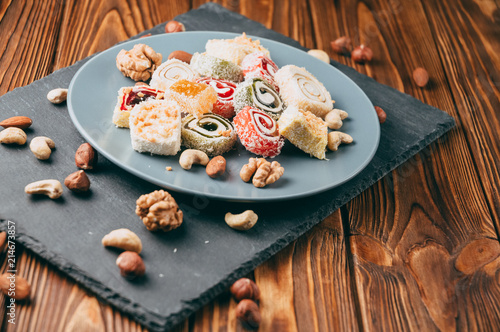 Bilde på lerret Traditional oriental sweets and nuts: hazelnuts, cashews on a brown wooden background