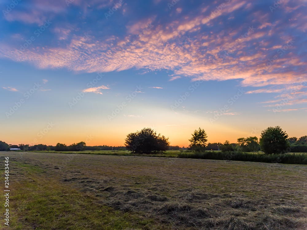 Sunset above hay meadow
