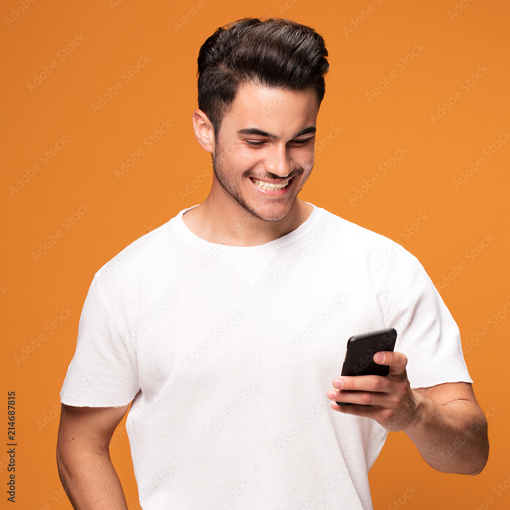 Smiling handsome man with mobile phone on yellow background. Smiling handsome man with mobile phone on yellow background.