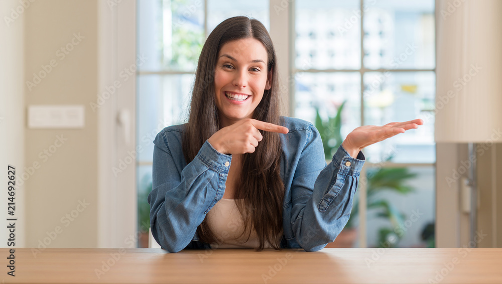 Young beautiful woman at home very happy pointing with hand and finger Young beautiful woman at home very happy pointing with hand and finger