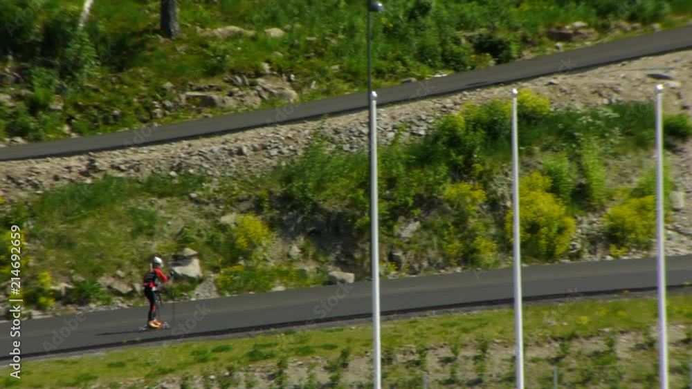 Roller Skiing Training On Hill Near The Holmenkollen Ski Jump. Children In Norway Learn This Sport At Young Age On Preparation For Cross-Country Skiing In The Winter. Roller Skiing Training On Hill Near The Holmenkollen Ski Jump. Children In Norway Learn This Sport At Young Age On Preparation For Cross-Country Skiing In The Winter.