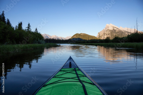 Kayaking in a beautiful lake surrounded by the Canadian Mountain Landscape. Taken in Vermilion Lakes, Banff, Alberta, Canada.